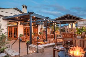 eine Terrasse mit Tischen und Stühlen und einem Kamin in der Unterkunft Casa Munras Garden Hotel & Spa in Monterey