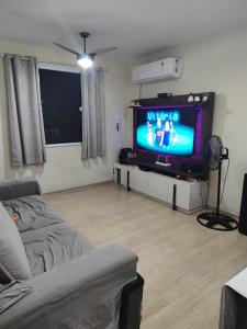 sala de estar con sofá y TV de pantalla plana en Casa ao Lado Estádio Nilson Santos, en Río de Janeiro