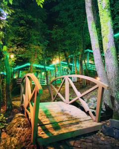 eine Holzbrücke mitten im Wald nachts in der Unterkunft Fanizan Otel&Restaurant in Altınordu