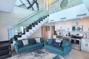 a living room with two blue couches and a staircase at Casa De Petrus-All Three Villas in East End