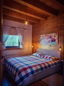 a bedroom with a bed with a checkered blanket at Family friendly house with a swimming pool Ogulin, Gorski kotar - 22843 in Ogulin