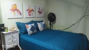 a bedroom with a blue bed and a dresser at Apto na praia do Centro Mongaguá ~ Ótima Localização in Mongaguá