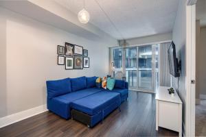 un sofá azul en la sala de estar con TV en Condo in the heart of Downtown Toronto! en Toronto