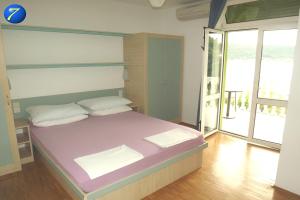 una camera da letto con un letto grande con vista sull'oceano di Rooms by the sea Supetarska Draga - Donja, Rab - 23068 a Rab