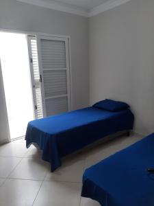 una camera con letto blu e armadio di lazer ou trabalho a Marília Altre 4 foto