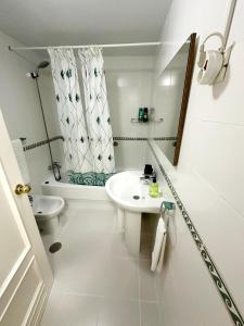 a white bathroom with a sink and a toilet at Málaga Capital - Zona Oeste: Parking-Wifi-Piscina in Málaga