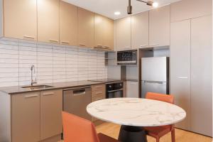 a kitchen with a table and orange chairs at CityLife Auckland in Auckland