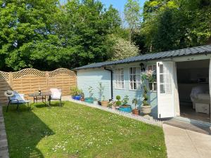 a backyard with a house and a table and chairs at Ty Hafan in Holywell