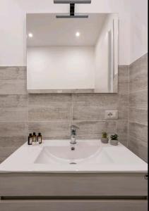 W łazience znajduje się biała umywalka i lustro. w obiekcie Iris home w mieście Camblione