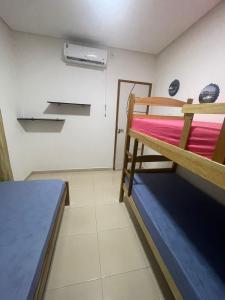 Kleines Zimmer mit einem Etagenbett und einem Ventilator. in der Unterkunft GREAT HOUSE in Manaus