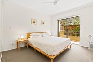 una camera bianca con un grande letto e una finestra di Spacious 2-Bed 2-Bath Moments from Avalon Beach a Avalon
