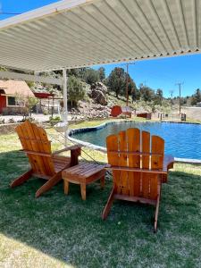 two chairs and a table under an umbrella next to a pool at Willow Springs Resort in Bridgeport