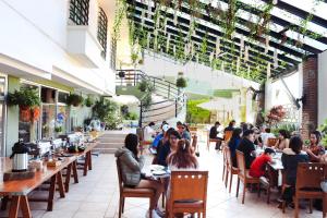 a group of people sitting at tables in a restaurant at Hotel Borda Cuernavaca in Cuernavaca