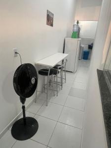 Zimmer mit einem Tisch, Stühlen und einem Kühlschrank in der Unterkunft GREAT HOUSE in Manaus