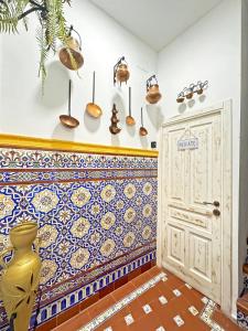 Habitación con pared de baldosa y puerta. en Palace-House Hércules 92 en Sevilla