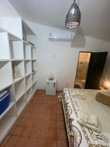 a bedroom with a bed in a room with shelves at Espaço Brilho do Sol Genipabu in Extremóz