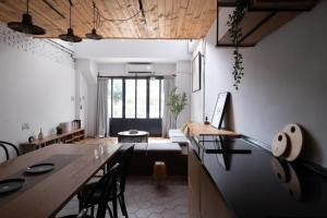 eine Küche und ein Wohnzimmer mit einem Tisch und einem Sofa in der Unterkunft 台中北歐包棟 in Taichung