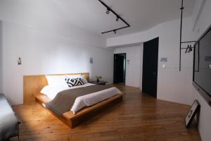 a bedroom with a large bed and a wooden floor at 逢甲包棟旅遊 in Taichung