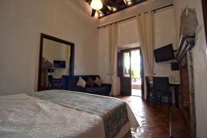 a bedroom with a bed and a couch and a mirror at Hotel Punto 79 in San Miguel de Allende