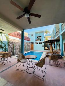 une terrasse avec une table, des chaises et une piscine dans l'établissement Rosarito Hotel, à Loreto