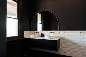 uma casa de banho com 2 lavatórios e um espelho em The Victoria Hotel Rutherglen em Rutherglen