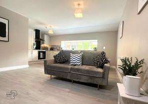 un soggiorno con divano e cuscini sopra di Hanley, Stoke - Modern Spacious Apartments by PolkaStays a Hanley