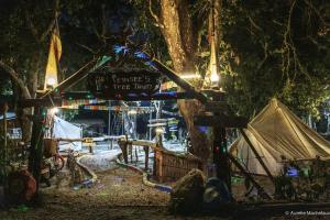 a tent and a sign in a forest at night at Pemsee's Tree Town in Sauraha