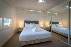 a bedroom with two beds and two windows at Blissful Beach Escape in Balgownie in Balgownie