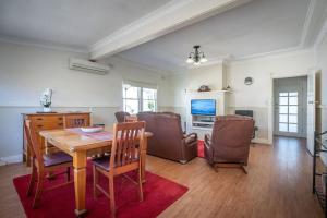 a dining room with a wooden table and chairs at Blissful Beach Escape in Balgownie in Balgownie