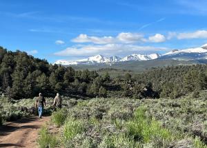 two people walking down a dirt trail with snow covered mountains at Willow Springs Resort in Bridgeport