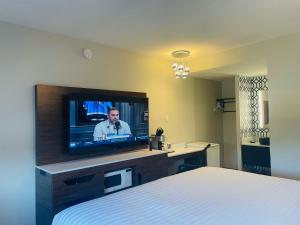 Habitación de hotel con TV y cama en The Cliffe en Courtenay