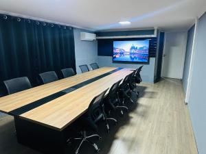 a conference room with a large wooden table and chairs at on park hotel e estacionamento traslado in Guarulhos