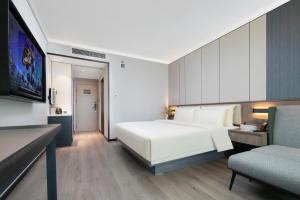 a bedroom with a large white bed and a chair at Atour X Hotel Ningbo Railway Station North Square in Ningbo +22 photos