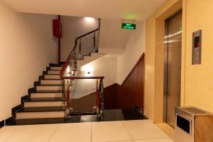 un escalier dans un bâtiment avec un panneau sur le mur dans l'établissement Prince Hotel, à Hô-Chi-Minh-Ville