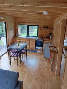 a kitchen with a table and chairs in a cabin at El Refugio Escondido in Puelo