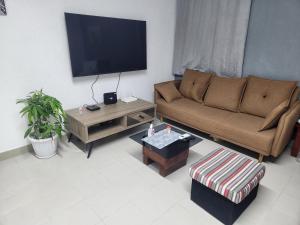 ein Wohnzimmer mit Sofa und Fernseher in der Unterkunft Expert Location Service in Abidjan