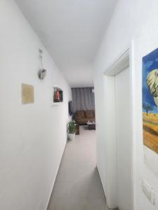 einen Flur mit weißen Wänden und einer weißen Tür in der Unterkunft Expert Location Service in Abidjan