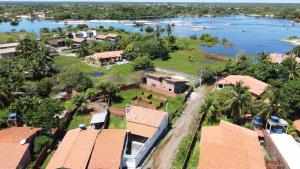 an aerial view of a house next to a river at Casinha de Sapê in Santo Amaro