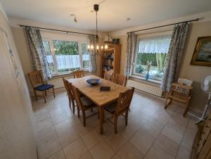 a dining room with a wooden table and chairs at Haus Piratenperle - Hooksiel in Wangerland