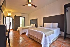 1 dormitorio con 2 camas y ventilador de techo en Hotel Punto 79, en San Miguel de Allende