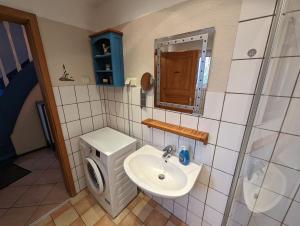 a bathroom with a sink and a toilet and a mirror at Haus Piratenperle - Hooksiel in Wangerland +50 photos