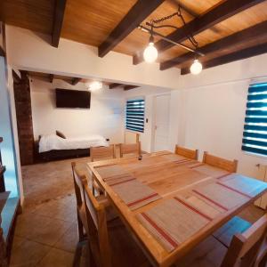 un comedor con una mesa de madera y una cama en USHUAIA MG, en Ushuaia