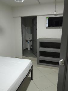 Habitación blanca con cama y baño. en Hotel Singapur en San José