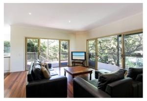 un soggiorno con due divani e una TV a schermo piatto di Peregian Beach, Noosa Shire Qld Aus a Peregian Beach