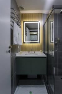 uma casa de banho com um lavatório, um espelho e um chuveiro em Studio Luxo Allianz Parque- Excelente Custo em São Paulo