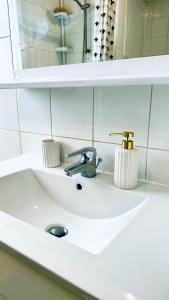 un lavandino con rubinetto e specchio di La Grey Room-Chambre Simple Privée - 700m Stade de France a Saint-Denis