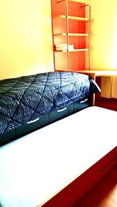 Una cama con una manta azul y blanca. en Acogedor piso en Puertollano en Puertollano