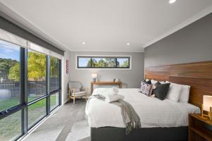 1 dormitorio con cama grande y ventana grande en Herlihys On Huon - Cabin 1, en Lymington