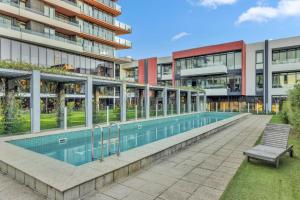 a swimming pool in front of a building at Tranquil 1-Bed Haven with Swimming Pool by CBD in Melbourne