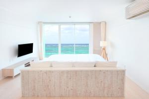 a bedroom with a bed and a large window at Pricia Resort Yoron in Yoron